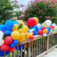 a group of balloons on a railing in front of a house