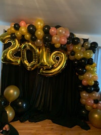 a black and gold balloon arch for a new year's party