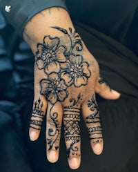 a woman's hand with henna tattoos on it