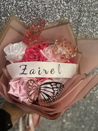 a bouquet of pink roses with a name written on it