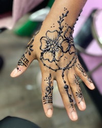 a child's hand with henna tattoos on it