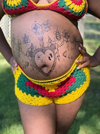 a pregnant woman with a colorful tattoo on her stomach