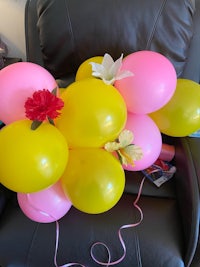 a bunch of balloons on a black chair