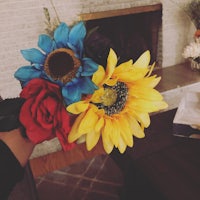 a person is holding a bouquet of flowers in front of a fireplace